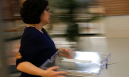 Une femme apporte une urne dans un bureau de vote de L'Hospitalet del Llobregat le 20 décembre 2017 à la veille des élections en Catalogne