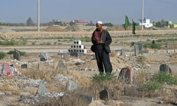 Photo prise le 1er juin 2025 près de kaboul de Gul Ajan Hotak priant sur la tombe de son défunt fils Shafiullah Hotak, mort après être tombé d'un avion C-17 de l'armée de l'air américaine pour fuir le pays dirigé par les talibans 