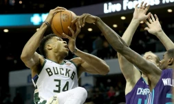 La mégastar des Bucks Giannis Antetokounmpo attaque le panier malgré Marvin Williams et Cody Zeller en défense pour les Hornets, le 26 novembre 2018 à Charlotte