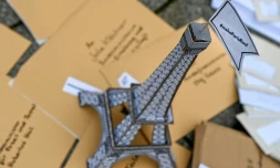 Une tour Eiffel en carton couronnée d'un drapeau: "Fais en sorte que Paris devienne une réalité" faite partie d'une installation posée par des activistes face à la porte de Brandenburg à Berlin le 11 décembre pour marquer les 5 ans de l'Accord de Paris sur le climat