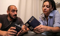 Nanor Abachian (d) et son mari Shadi Abi Haidar regardent leurs passeports, chez eux, à Beyrouth, le 31 août 2021 au Liban