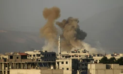 De la fumée s'élève après un bombardement du régime au-dessus de la ville sous contrôle rebelle de Saqba, dans la Ghouta orientale, près de Damas, le 11 mars 2018