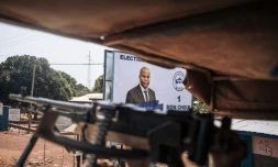 Des casques bleus égyptiens patrouillent dans Bangui, devant une affiche électoral du président Faustin Archange Touadéra, le 25 décembre 2020