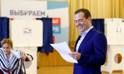 Le Premier ministre russe Dmitri Medvedev sourit en tenant un bulletin dans un bureau de vote à Moscou, le 9 septembre 2018