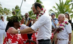 Le Premier ministre Edouard Philippe (d) reçoit un collier de fleurs lors d'une cérémonie de bienvenue sur l'île de Tiga, le 3 décembre 2017 en Nouvelle-Calédonie