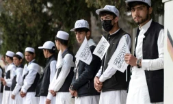 Des élÚves tiennent des drapeaux talibans pendant une cérémonie marquant la rentrée scolaire,à l'école Amani de Kaboul, le 20 mars 2024 en Afghanistan