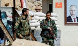 Des forces progouvernementales syriennes devant des portraits des présidents russe et syrien, Vladimir Poutine et Bachar al-Assad, au passage d'Al-Wafidine à la limite de la Ghouta orientale, le 1er mars 2018