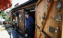 Peter McLaughlin à l'entrée de son abri de jardin, aménagé pour reproduire la chaufferie d'un navire, à l'arrière de sa maison à Londres, le 31 juillet 2026