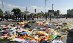 Des policiers autour des corps de victimes, recouverts de drapeaux, du double attentat qui a fait au moins 86 morts Ă Ankara en Turquie, le 10 octobre 2015