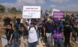 Des militants israéliens et des bénévoles solidaires rassemblés devant une maison palestinienne assiégée par des colons israéliens dans le village de Qusra, au sud de Naplouse, en Cisjordanie occupée, le 14 août 2026