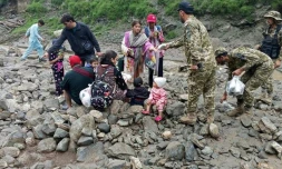 Photo publiée le 22 juillet 2025 par le gouvernement du Gilgit-Baltistan de soldats de l'armée pakistanaise aidant des personnes à évacuer la zone touchée par un glissement de terrain à Babusar, au Pakistan