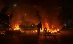 Un homme jette un pneu dans un feu lors d'affrontements avec la police, alors que des manifestants protestent contre les résultats préliminaires du second tour de l'élection présidentielle à Bogotá, en Colombie, le 21 juin 2026