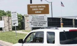 Une voiture passe devant des panneaux à l'entrée du pénitencier militaire de Fort Leavenworth, le 16 mai 2017 aux Etats-Unis