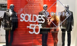 Une jeune femme met la dernière main à l'installation d'une vitrine à l'occasion du lancement des soldes, à Talange (Moselle), le 2 janvier 2018