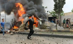 Des habitants courent dans une rue de la ville rebelle d'Azaz après l'explosion d'une voiture piégée, le 3 mai 2017 dans le nord de la Syrie