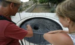 Des touristes devant l'oeuvre du plasticien britannique Anish Kapoor intitulée "Descension" à la Biennale d'art contemporain de Bonifacio, en Corse-du-Sud, le 21 juin 2022
