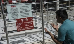 Un homme prie devant la tombe d'Omer Halisdemir, célèbre "martyr" du putsch manqué du 15 juillet 2016, le 10 juillet 2017 au cimetière de Cukurkuyu, en Turquie