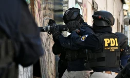 Des policiers pénÚtrent dans une habitation lors d'une opération antidrogue à Santiago, le 11 décembre 2025