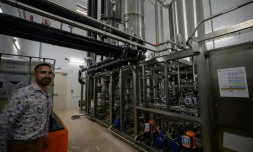 Un employé pose à côté d'une unité de désalcoolisation du vin dans le laboratoire du Chai sobre, le 25 juin 2025 à à Vic-Fezensac, dans le Gers 