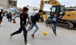 Des enfants jouent au football dans une rue du quartier populaire d'Ettadhamen, en banlieue de Tunis, le 30 avril 2018