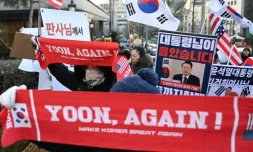 Des partisans de l'ancien président sud-coréen destitué, Yoon Suk Yeol, rassemblés devant le tribunal du district central de Séoul où doit se tenir son dernier procès pénal pour insurrection, le 13 janvier 2026