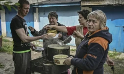 Des habitants de Lyssytchansk, en Ukraine, cuisinent à l'extérieur de leurs habitations, le 26 mai 2022