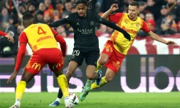 L'attaquant parisien Bradley Barcola (c) entre les Lensois Kevin Danso et Przemyslaw Frankowski, le 14 janvier 2024 Ă Lens