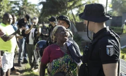 Une femme interppelle un gendarme français lors de la démolition d'un campement informel à Longoni, sur la commune de Koungou, le 27 avril 2023 à Mayotte