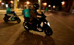 Deux liveurs Ă scooter Deliveroo traversent la Place Saint Pierre Ă Toulouse, le 16 janvier 2021