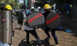 Des manifestants pro-démocratie se défendent face aux forces de l'ordre birmanes, à Rangoun, le 7 mars 2021