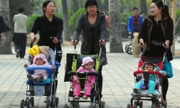 Des femmes avec des enfants en poussette à travers un parc de Pékin, le 5 avril 2011