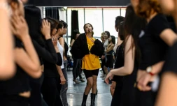 Pham Kieu Ly (C) explique à ses élÚves comment prendre la pose pour se photographier avec leur téléphone portable, dans un studio à Hanoï le 2 mars 2021