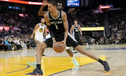 Le Français Victor Wembanyama, des San Antonio Spurs, passe Andrew Wiggins, des Golden State Warriors, lors d'un match d'avant-saison entre les deux franchises NBA, à San Francisco, le 20 octobre 2023