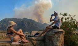 Des touristes devant un incendie sur la côte sud de la Turquie, près de la ville de Marmaris, le 30 juillet 2021