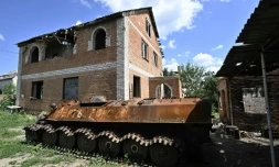 Un blindé russe détruit devant une maison endommagée, le 28 juillet 2022 à Mala Rogan, dans la région de Kharkiv, en Ukraine