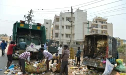 Des employés municipaux ramassent des ordures dans une zone résidentielle de Bangalore, le 11 janvier 2017 en Inde