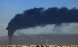 Une photo prise de Rafah montre un nuage de fumée au dessus de Khan Younès dans le sud de Gaza après des bombardements israéliens le 21 janvier 2024