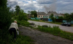 Une femme s'abrite des bombardements dans un village récemment repris aux forces russes, près de kharkiv, le 25 mai 2022