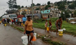 Des résidents du quartier de Bhambayi viennent s'approvisionner en eau potable aprÚs la rupture des canalisations ravagées par les inondations, à Durban le 15 avril