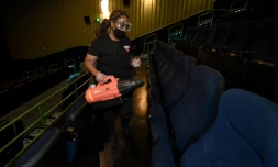Une employée d'un cinéma de Las Vegas désinfecte des fauteuils