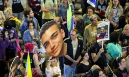 Une manifestante tient une photo géante de l'otage israélo-américain Edan Alexander, au centre, le 15 mars 2025, lors d'une manifestation à Tel Aviv, en Israël