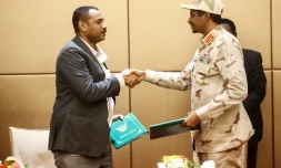 Le numéro deux du Conseil militaire au pouvoir au Soudan Mohammed Hamdane Daglo (droite) et le leader de la contestation Ahmed Rabie se serrent la main aprÚs avoir signé la déclaration constitutionnelle actant la création d'un pouvoir civil, le 4 août 2019 à Khartoum