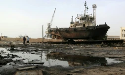Des ouvriers inspectent les dommages causés par une frappe aérienne sur le centre de maintenance du port de Hodeidah, le 27 mai 2018