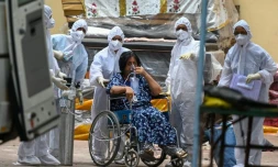 Une femme est emmenĂ©e par des ambulanciers pour ĂȘtre transportĂ©e dans une unitĂ© de soins intensifs pour patients atteints du Covid-19, le 22 avril 2021 Ă Bombay, en Inde