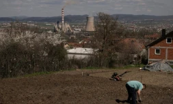 Un homme travaille dans son jardin qui surplombe une centrale thermique au charbon, près de la ville d'Obilic, au Kosovo, le 10 avril 2026