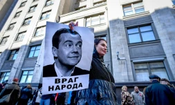 Un manifestant brandit une photo du Premier ministre russe Dmitri Medvedev sous laquelle on peut lire "Ennemi du peuple" au cours d'un rassemblement contre la réforme des retraites, à Moscou le 26 septembre 2018.