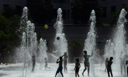Des enfants jouent avec des jets d'eau au parc André Citroen le 26 juillet 2018 à Paris