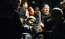 Des policiers solvènes enregistrent les migrants à  bord d'un bus le 21 octobre 2015 à Brezice en Solvénie