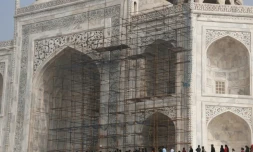 Des touristes visitent le Taj Mahal et passent devant des échafaudages installés pour rénover le monument, à Agra en Inde, le 3 janvier 2018