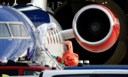 Une personne en combinaison blanche débarque le 6 mai 2026 d'un avion médicalisé Bombardier Challenger 605 censé transporter des passagers du bateau de croisière MV Hondius touché par une épidémie d'hantavirus